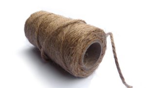 红色丝绳细线卷盘近景，光泽感强，用于中国传统绳艺中国结编制，色泽鲜艳喜庆